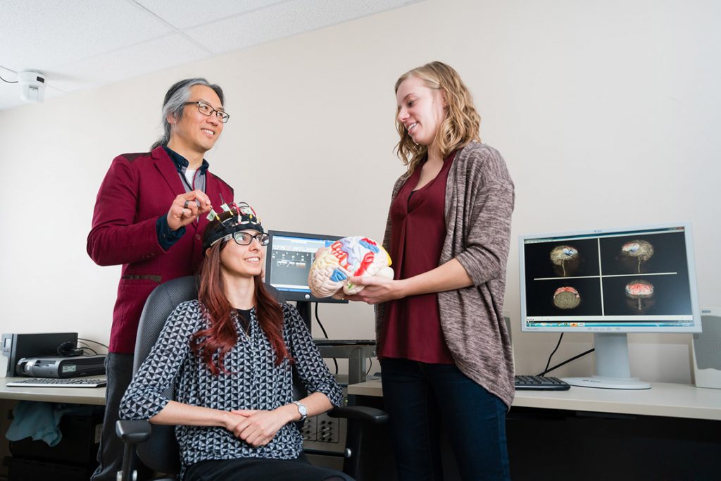 Professor Tom Chau, a University of Toronto pediatric rehabilitation engineer, works with two graduate students to develop a brain-computer interface for children
