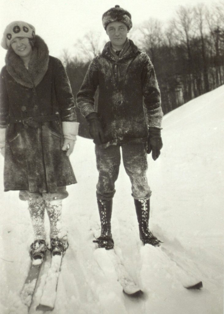 In February, 1924, James Havens smiles as he stands on skis on a snowy hill, with his clothes covered in powdered snow.