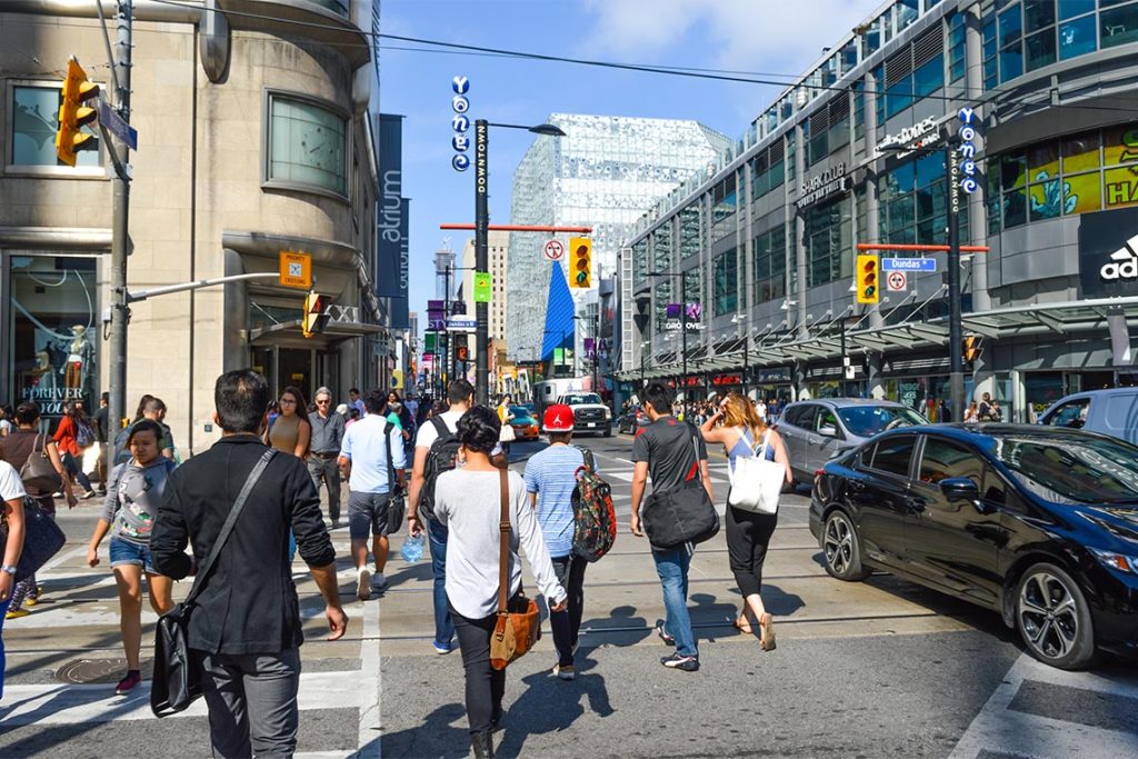 Toronto, Canada - August 30, 2016: Pedestrians crossing a busy intersection near Dundas Square on Queen Street, in Toronto